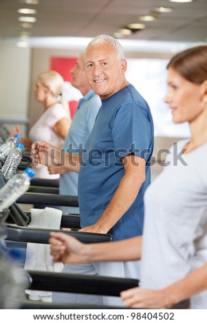 Senior citizens doing a treadmill training in fitness center