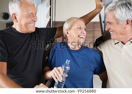 Happy senior group with men and woman chatting in a gym