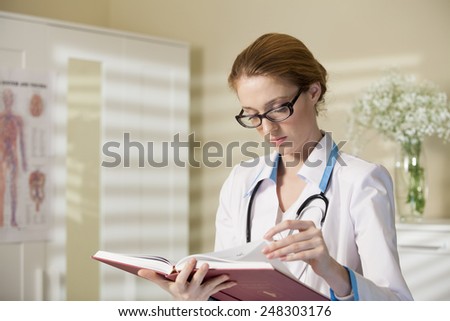 Young beautiful doctor with book