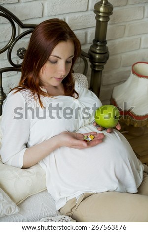 Beautiful young pregnant woman on the bed
