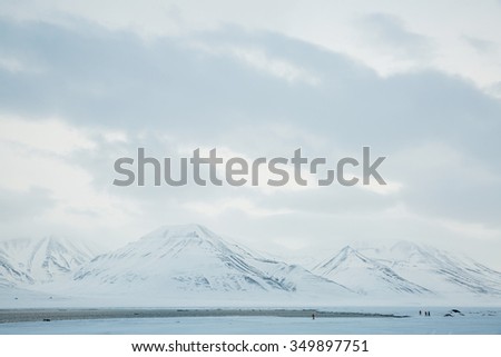 The waves of the Arctic Ocean and the snow-capped mountains of the Spitsbergen archipelago.