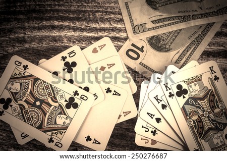 Two pairs and three of a kind vintage poker cards with money on a wooden background