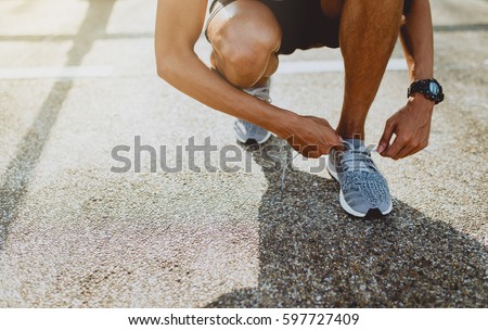 Runner trying running shoes getting ready for run. Healthy lifestyle.