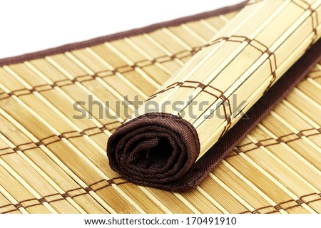 Rolled bamboo mat on a bamboo mat on a white background