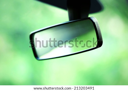 Car rear view mirror on green background