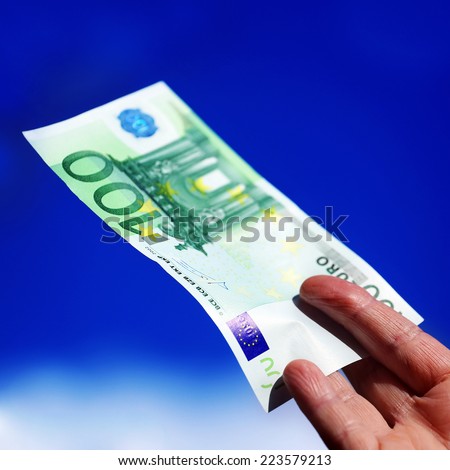 Euro in a hand. Sky background.