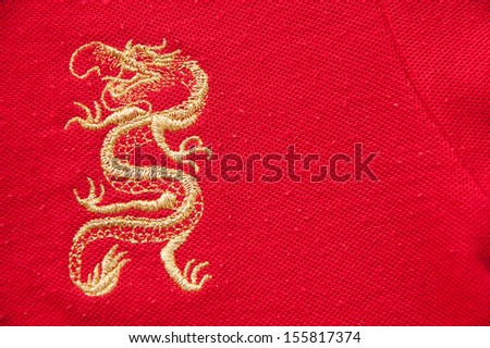 The golden dragon in golden thread sewed on the red fabric.