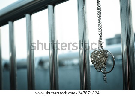 The coil of metal heart  hung at the bar waiting for someone found it.