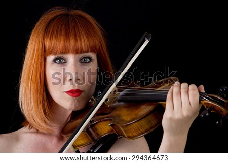 violin player woman with red hair close up isolated on black background