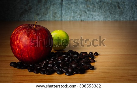 Red Apple, Lime and Coffee bean on a wood with Dramatic Lighting, Selective focus, Vintage tone.