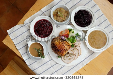 Roast Turkey Breast with Stuffing, Gravy, Apple Sauce, Braised Red Cabbage, Cranberry Sauce on a table, Selective focus - From above