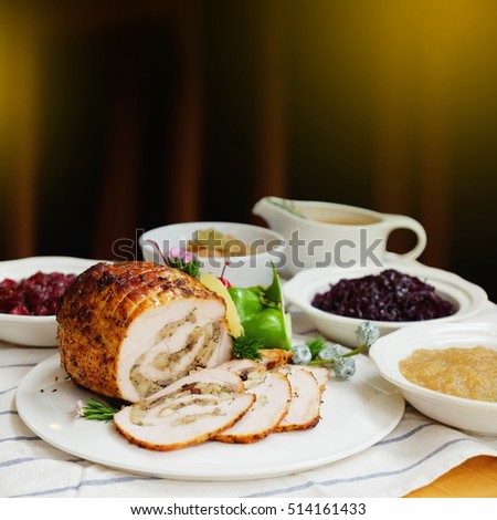 Roast Turkey Breast with Stuffing, Gravy, Apple Sauce, Braised Red Cabbage, Cranberry Sauce on Christmas dinner table - Copy space