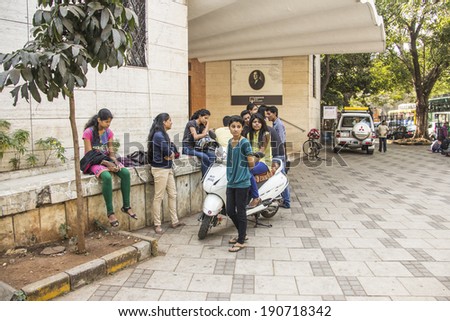 BOMBAY, INDIA - JANUARY 30, 2014: A group of stylish indian youths is sitting in front of Jehangir Gallery, Bombay