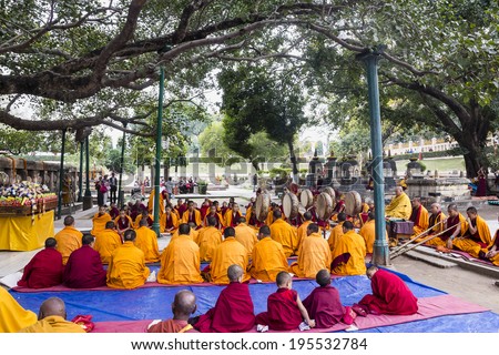 BODHGAYA, INDIA - FEBRUARY 26, 2014: Tibetan monks are celebbrating a ceremony beneath the bodhi tree, under which the buddha became enlightened. They are chanting, and holding up their drums