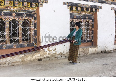 PHOBJIKHA VALLEY, BHUTAN - MARCH 03, 2014: woman weaving at gangtey village. It is a beautiful village with a well known monastery in Bhutan