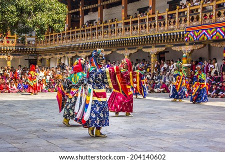 PUNAKHA, BHUTAN - MARCH 8, 2014:  masked dancers at  drupchen festival in the dzong of Punakha, Bhutan. Drupchen festival is taking place yearly in march.
