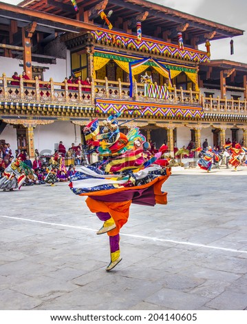 PUNAKHA, BHUTAN - MARCH 8, 2014: A whirling masked dancers at  drupchen festival in the dzong of Punakha, Bhutan. Drupchen festival is taking place yearly in march.
