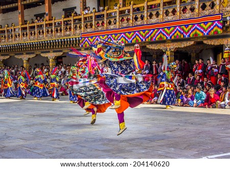 PUNAKHA, BHUTAN - MARCH 8, 2014:  masked dancers at  drupchen festival in the dzong of Punakha, Bhutan. Drupchen festival is taking place yearly in march.