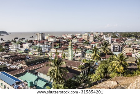 A view from th mountain over the roofs of Myeik in the south of Myanmar. In the Background is the harbor of Myeik.