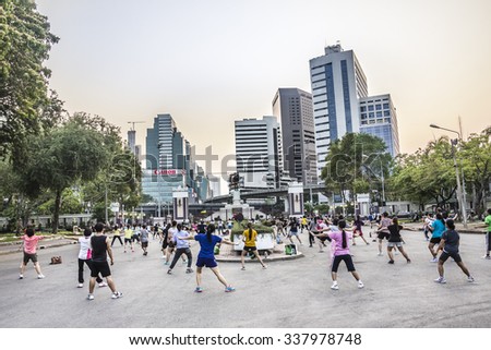 BANGKOK, THAILAND - MARCH 11, 2015: Many Thai people of every age participate in keep-fit exercises at Lumphini Park in the evening.