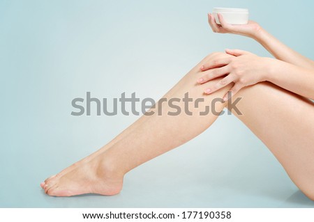 Woman applying cream on feet