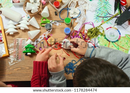 Childrens making decorations for new year holiday. Painting watercolors. Top view. Artwork workplace with creative accessories.