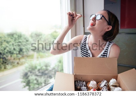 girl eating tasty cakes, sitting by the window, sweet food and pleasure