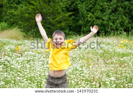 boy jumping on the flower meadow