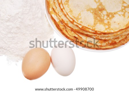 Pancake on a dish, a handful flour, and eggs isolated