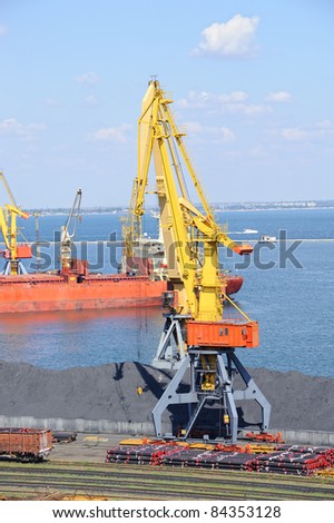Industrial port with cargo. Coal, tubes, ship, cranes. Railroad and car.