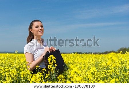 business woman with briefcase at the yellow flower field