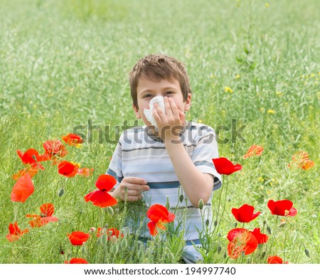 allergy boy with handkerchief on red flower meadow