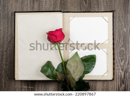 photo album and roses on wood background