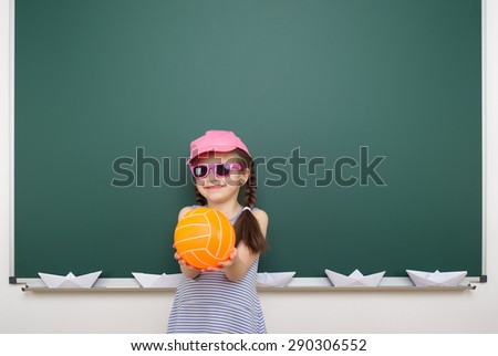 Schoolgirl with ball near the school board