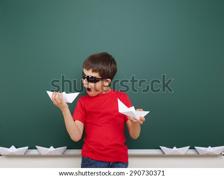 boy with origami toy near the school board