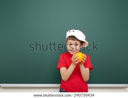boy with orange fruit near the school board