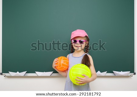 Schoolgirl with ball near the school board