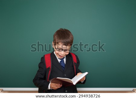 Schoolboy with backpack on school board background