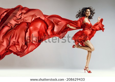 Woman in red waving dress with flying fabric