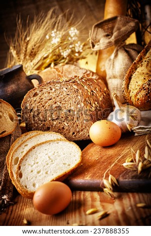 Country still life with bread, cheese, mushrooms and wine in an antique jar