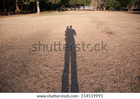 Long shadow of child and father