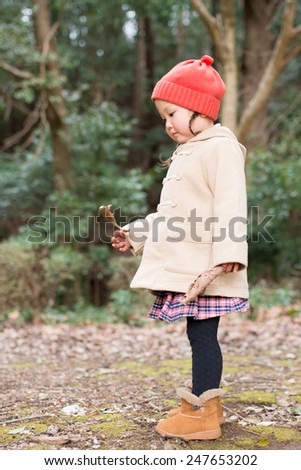 Girl pick up the fallen leaves