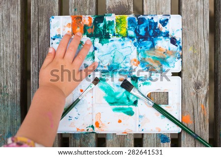 The hands of Child to touch a final palette of paint