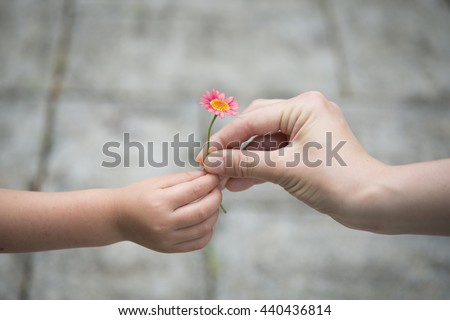 Mother and Child handing a pink flower