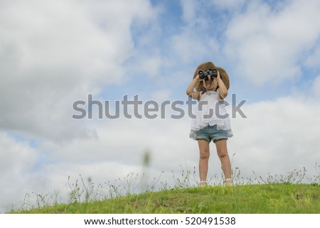 Little girl looking far away with binoculars