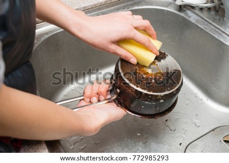 Women's hands to polish burned pot