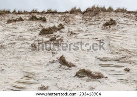 Side of a sand dune eroded by wind and water in a beach in UK