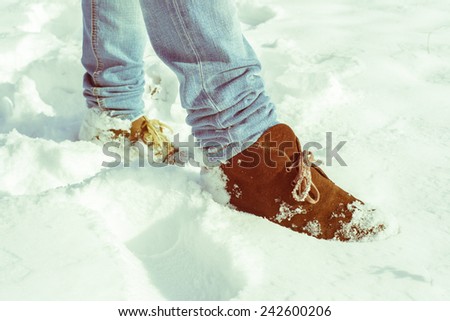 Brown suede Desert Boots covered in snow walking on a snowy field. Instagram effect