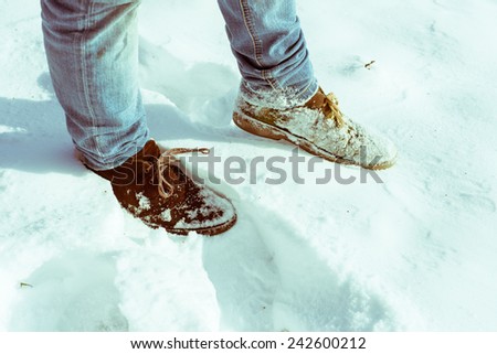 Brown suede Desert Boots covered in snow walking on a snowy field.
