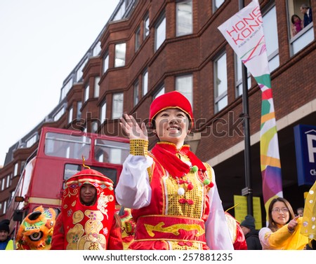 London, UK - 22 February 2015: Lady dressed in traditional Chinese clothes waving her hand during a parade. Part of the celebrations for the Chinese new year 2015 in Chinatown.